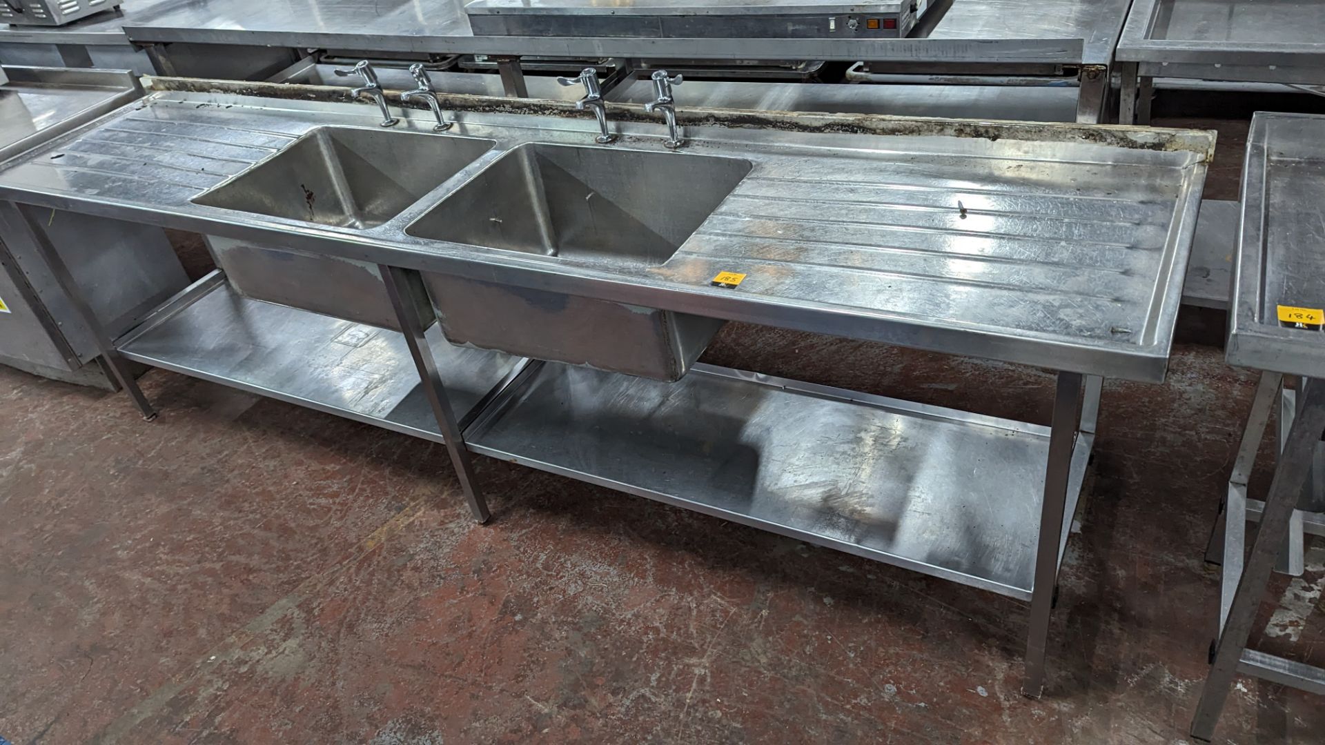 Extra long stainless steel twin bowl sink with drainers to either side & shelves below. Max externa