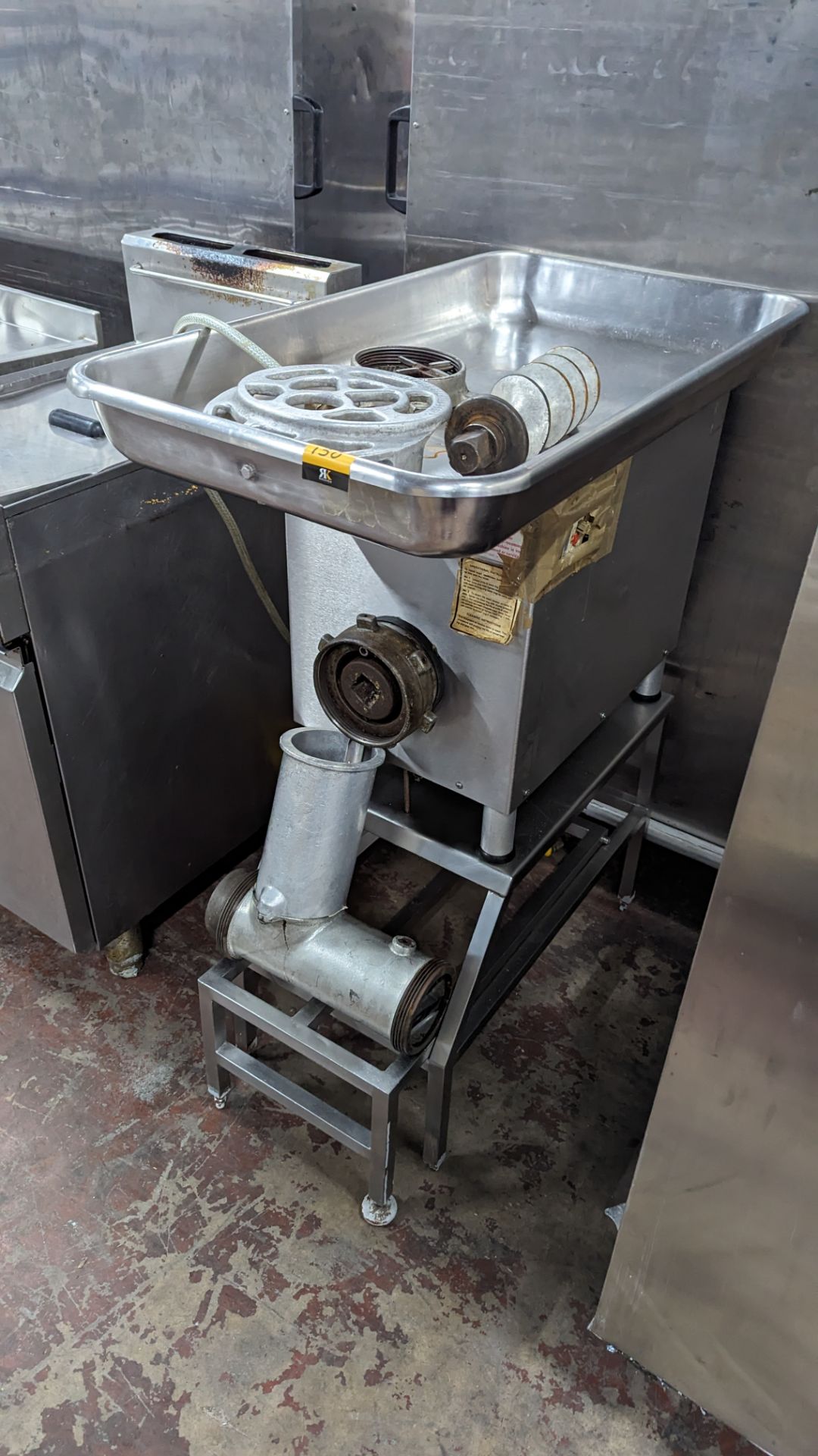 Commercial mincer on dedicated stand with assorted ancillaries