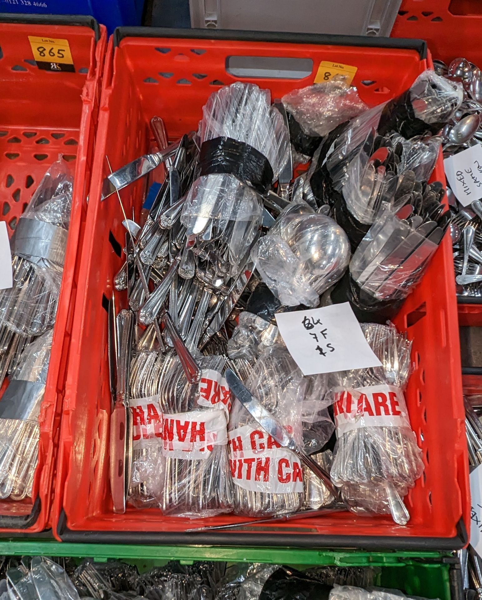 The contents of a crate of cutlery. Approximately 700 pieces, made up of 14 bags each with 50 piece