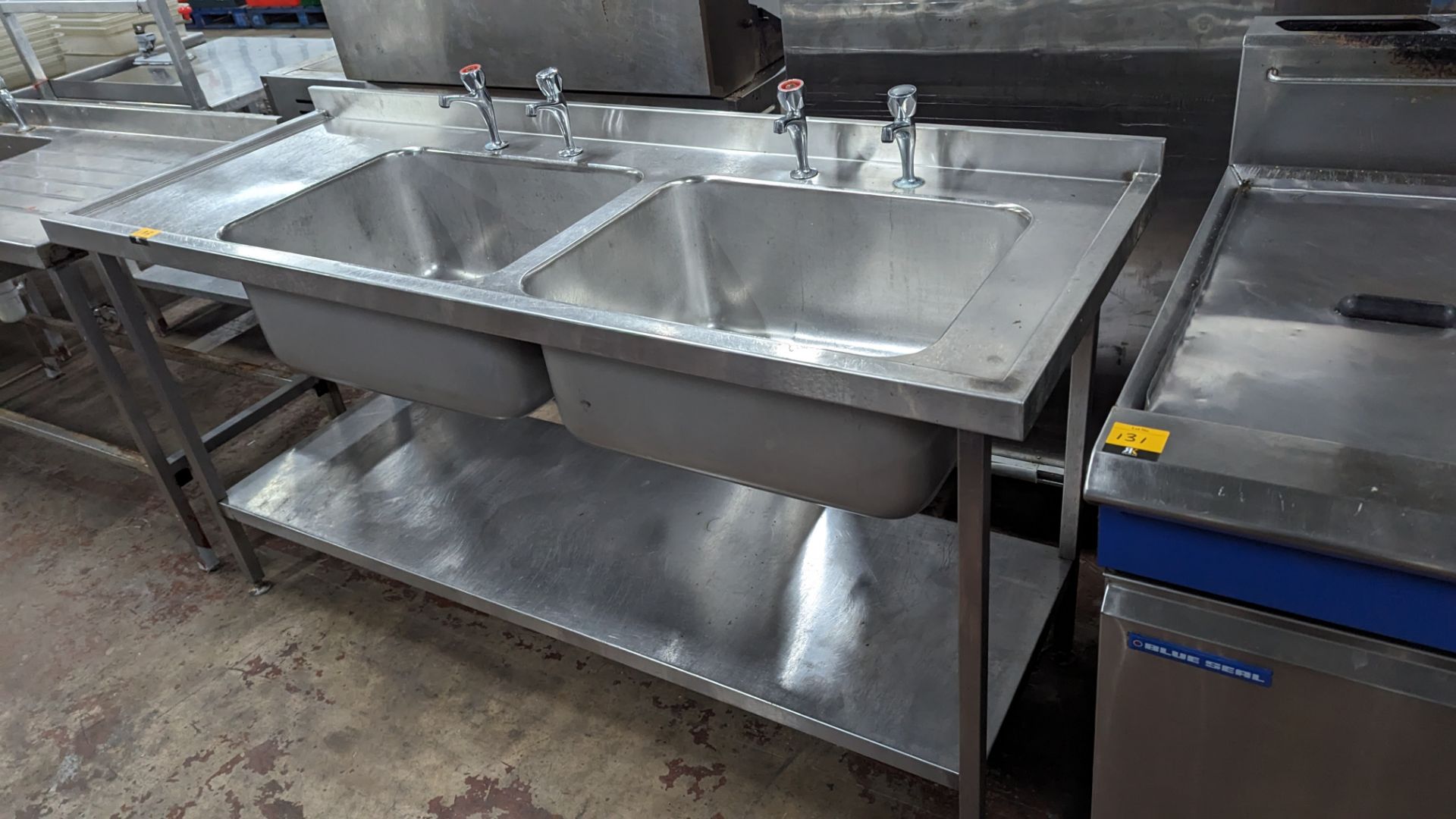 Large stainless steel floor standing twin bowl sink arrangement with built-in drainer & a pair of ta