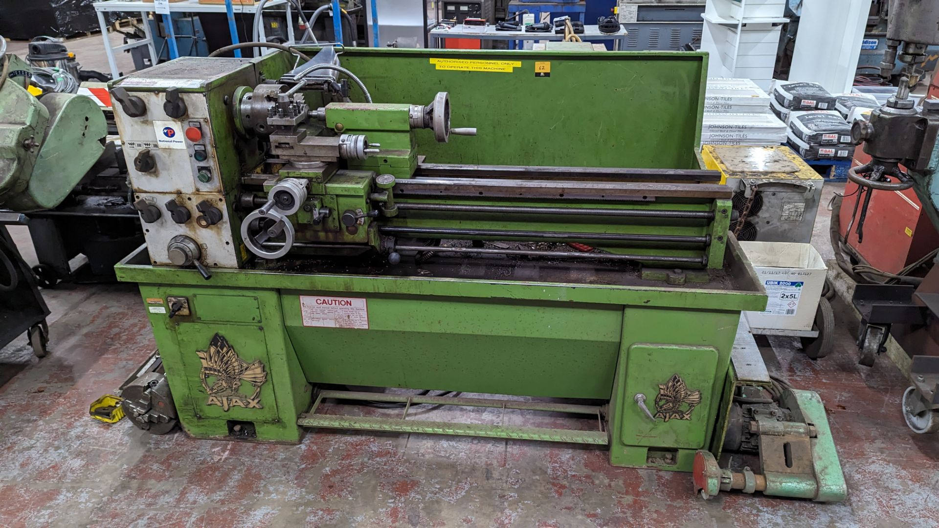 1989 Ajax lathe including tooling on the floor located to the left, as pictured