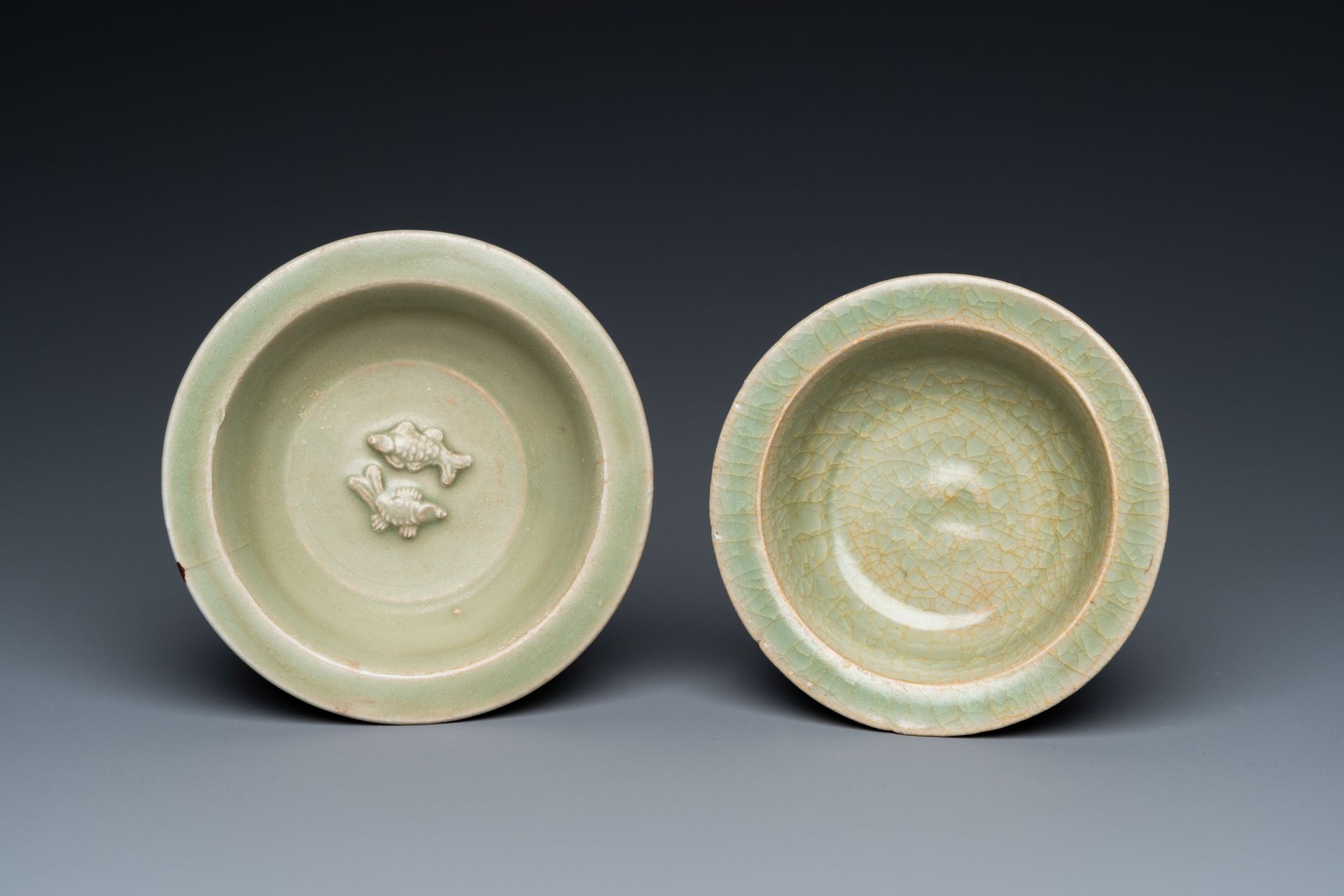 Two Chinese celadon-glazed bowls, one with twin fish, Ming