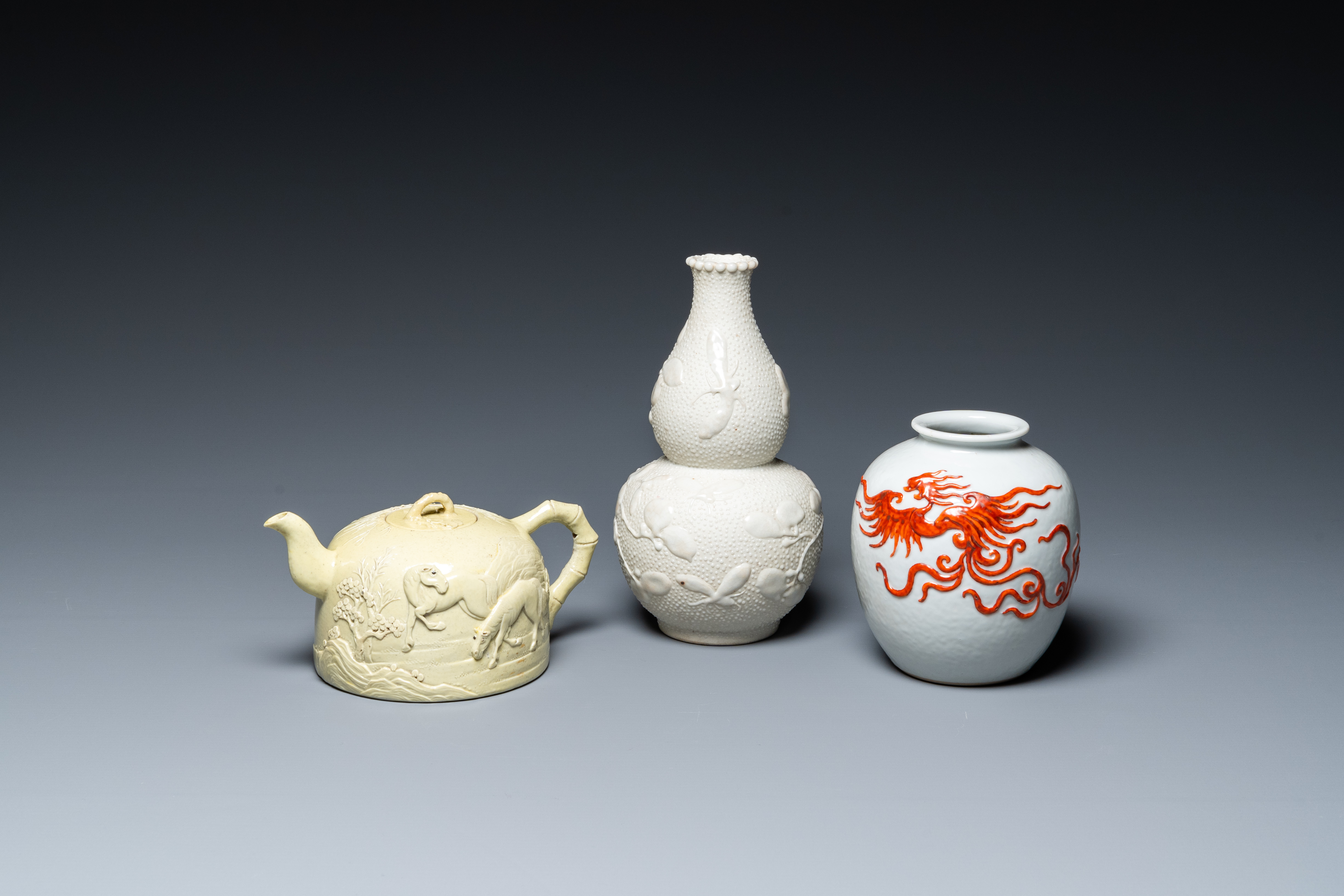 A Chinese yellow-glazed biscuit teapot, a white-glazed biscuit double gourd vase and an iron-red 'ph