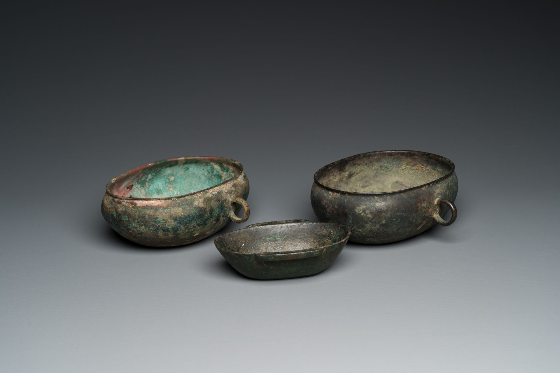 Three Chinese elliptical bronze cups, Eastern Zhou and Han