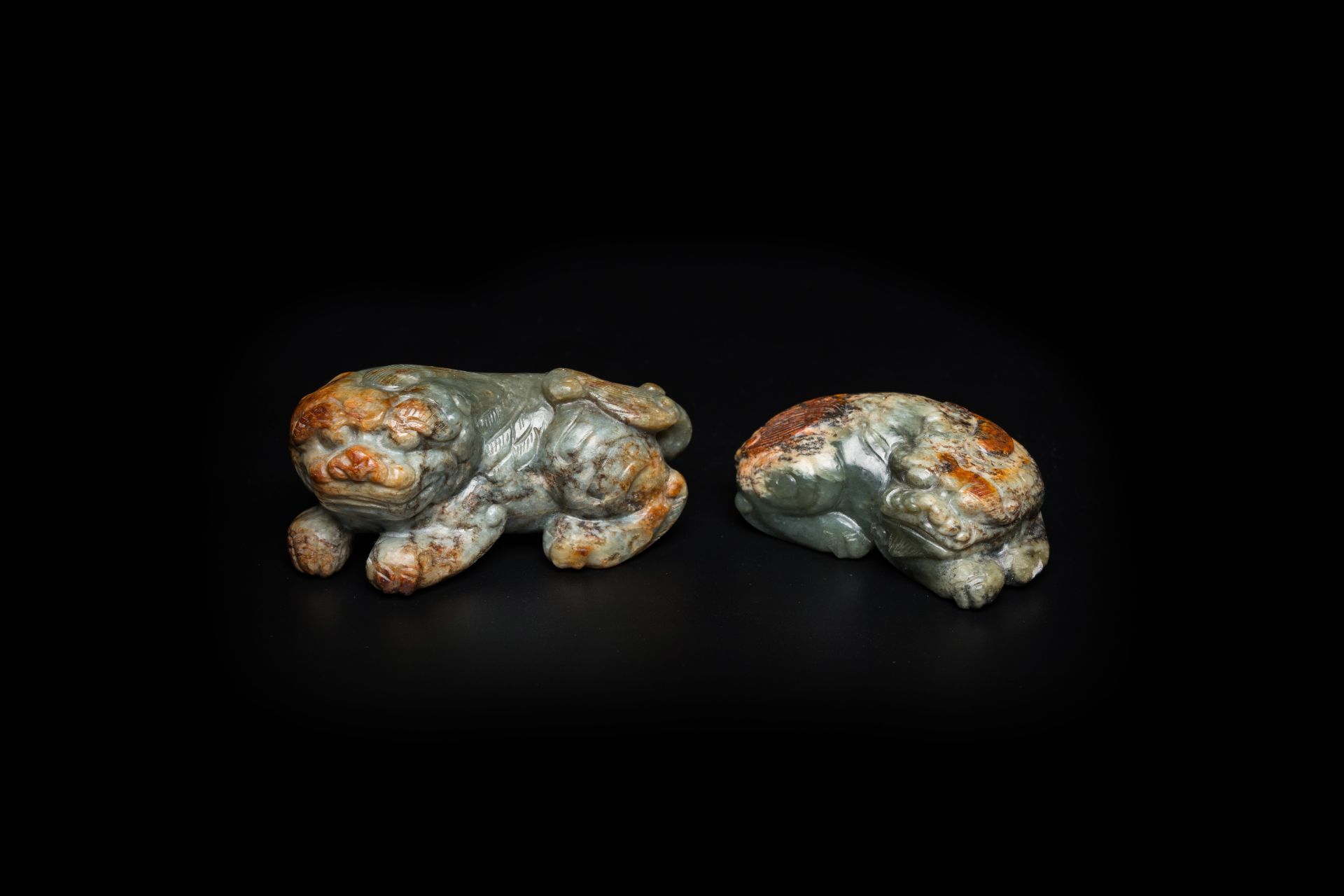 Two Chinese celadon and russet jade Buddhist lion sculptures, Qing