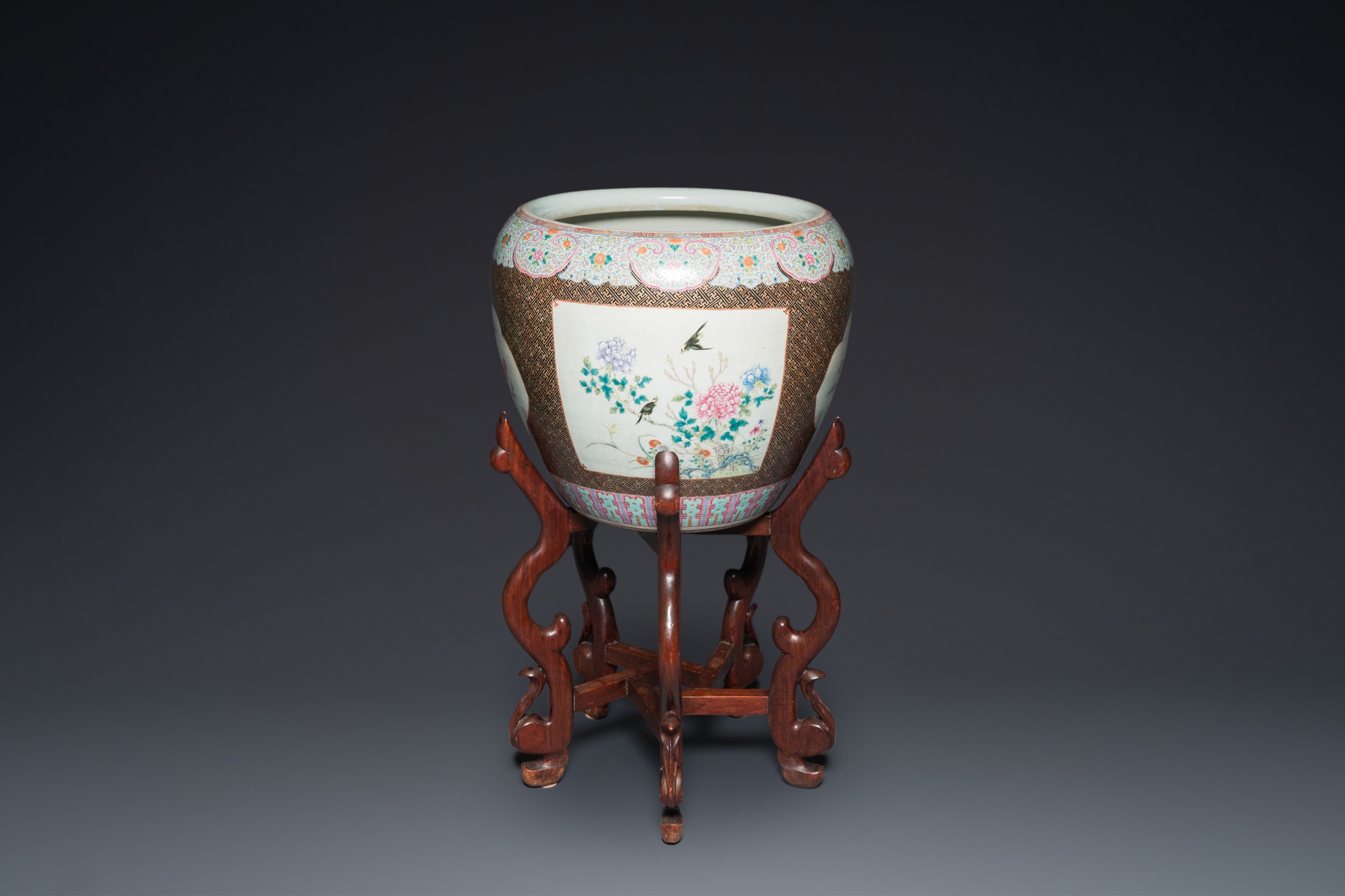 A large Chinese famille rose fish bowl on wooden stand, 19th C.