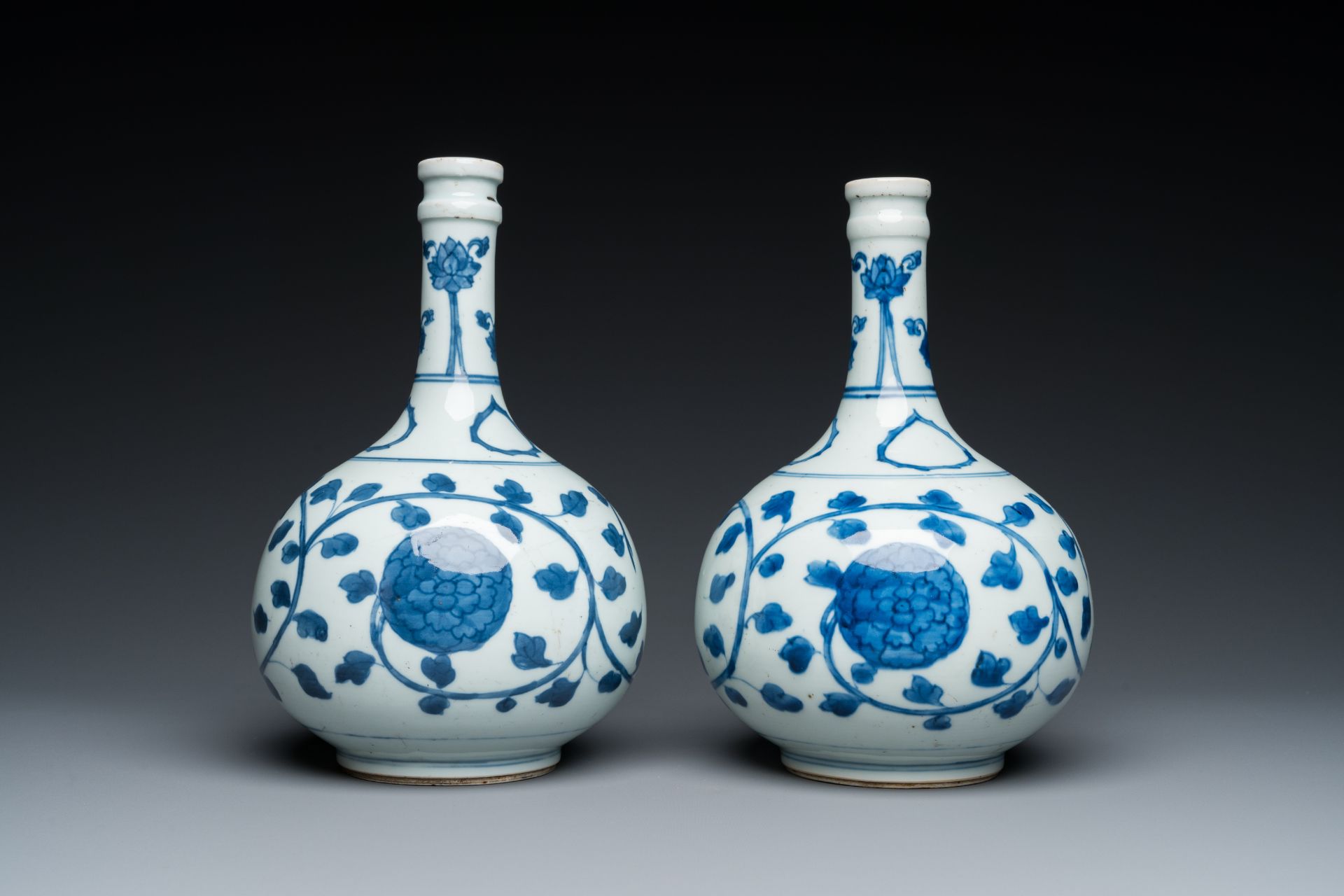 A pair of Chinese blue and white 'peony scroll' pharmacy bottles, Kangxi