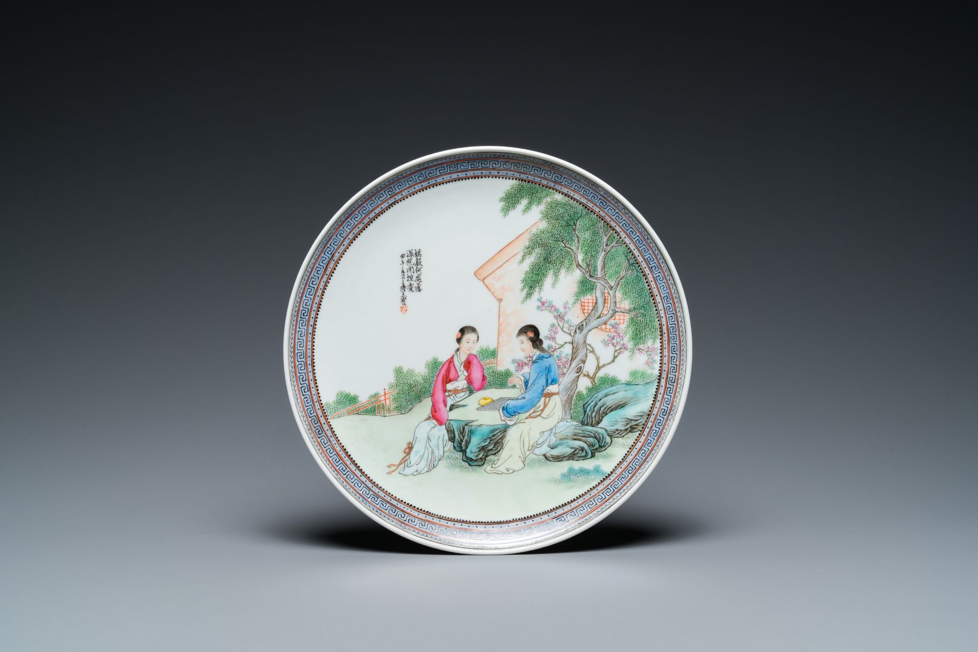 A Chinese famille rose dish with ladies playing go, signed Wanglong Fu ___, dated 1954