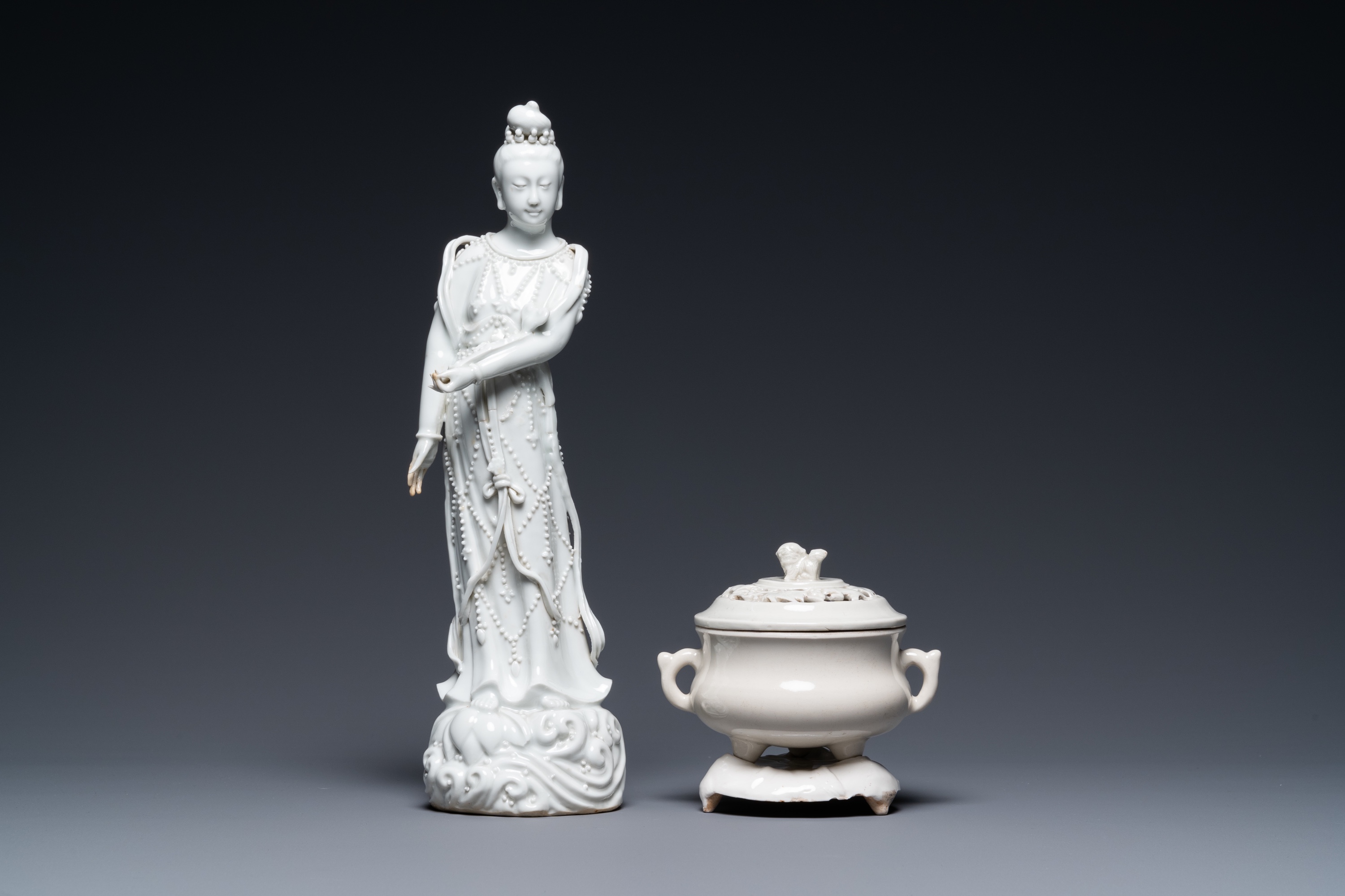 A Chinese Dehua blanc de Chine figure of Guanyin and a covered censer on stand, 18/19th C.