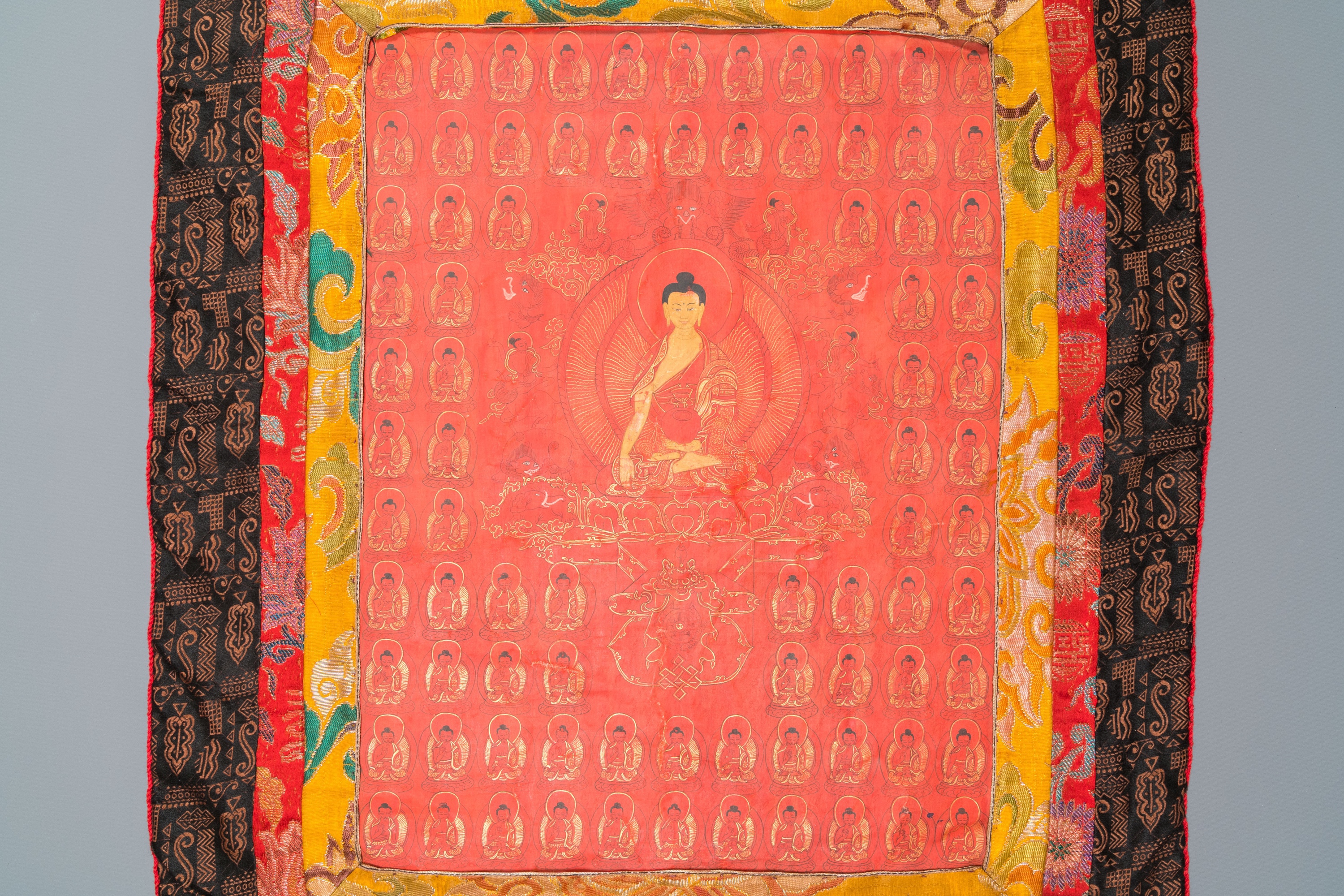 A red-ground thangka depicting the Medicine Buddha or Bhaishajyaguru surrounded by Shakyamuni Buddha - Image 2 of 4