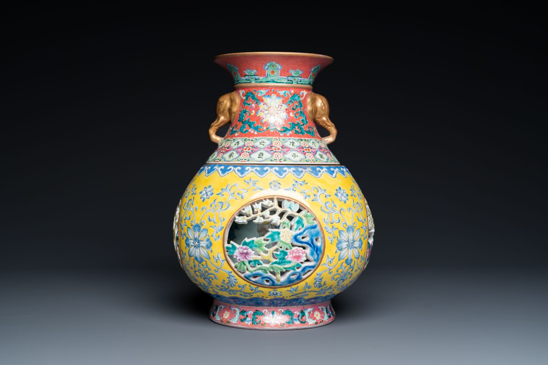 A Chinese reticulated and revolving famille rose vase consisting of two parts, Qianlong mark, 20th C