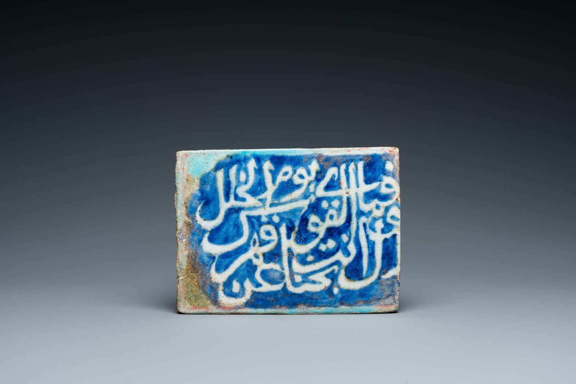 An Islamic calligraphic tile in blue, turquoise and white, 17th C.