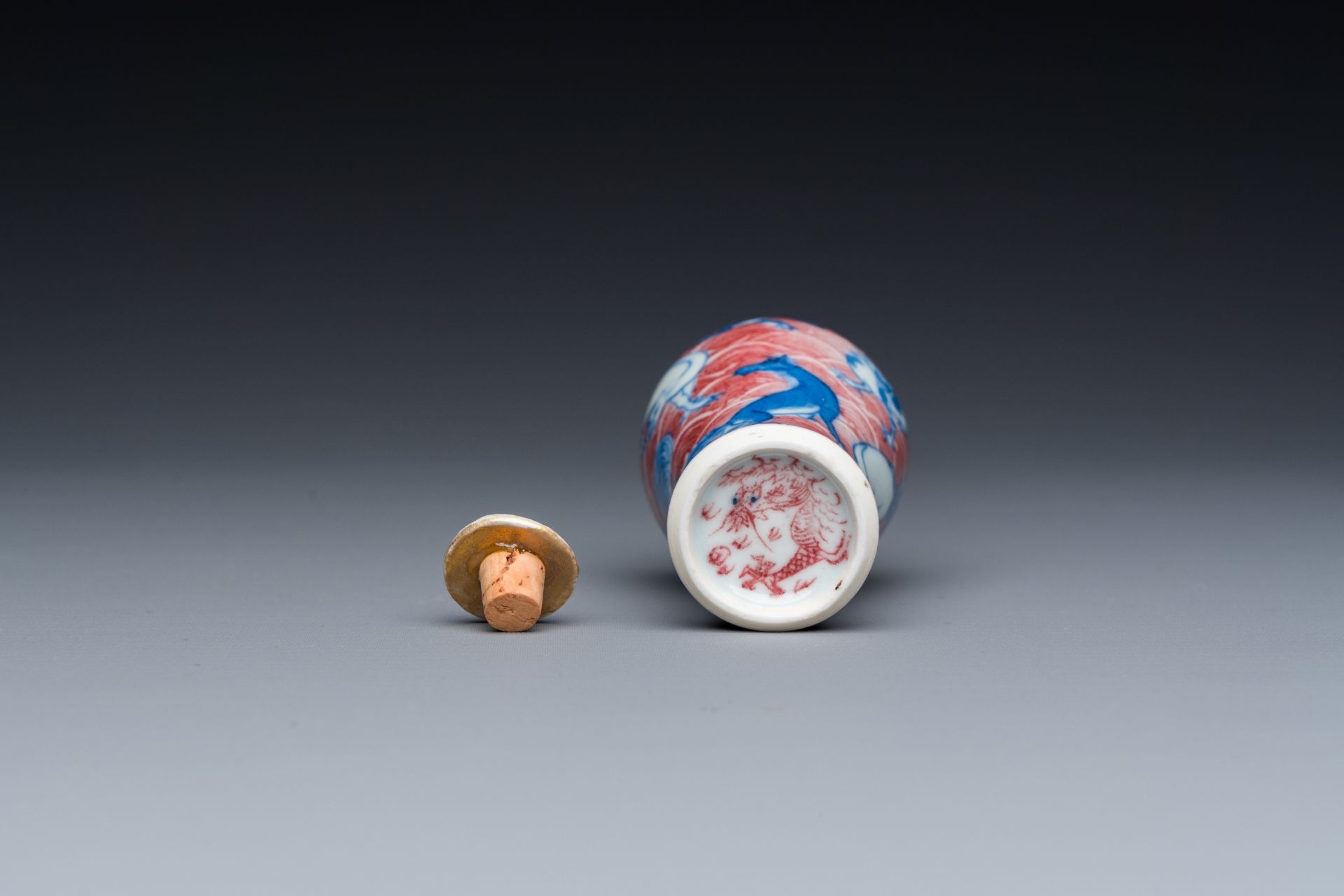 A Chinese blue, white and copper-red 'dogs' snuff bottle, 19th C. - Image 6 of 6