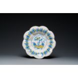 A blue, white and yellow Dutch Delftware dish with a putto holding a falcon, Delft or Haarlem, 17th