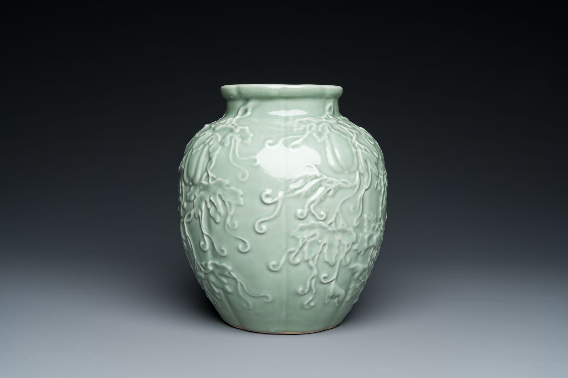 A Chinese relief-molded monochrome celadon-glazed vase, 19/20th C. - Image 4 of 6