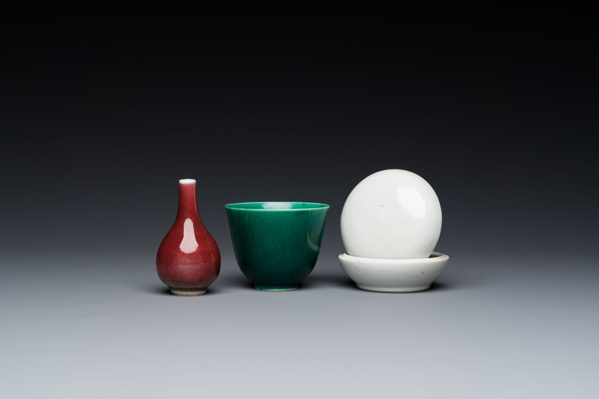 A Chinese monochrome copper-red vase, a green anhua 'dragon' cup and a white-glazed box and cover, 1