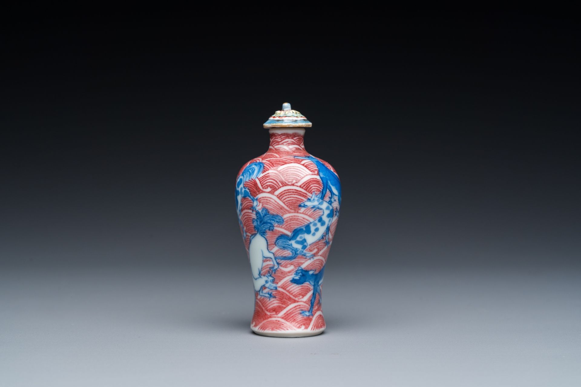 A Chinese blue, white and copper-red 'dogs' snuff bottle, 19th C. - Image 2 of 6