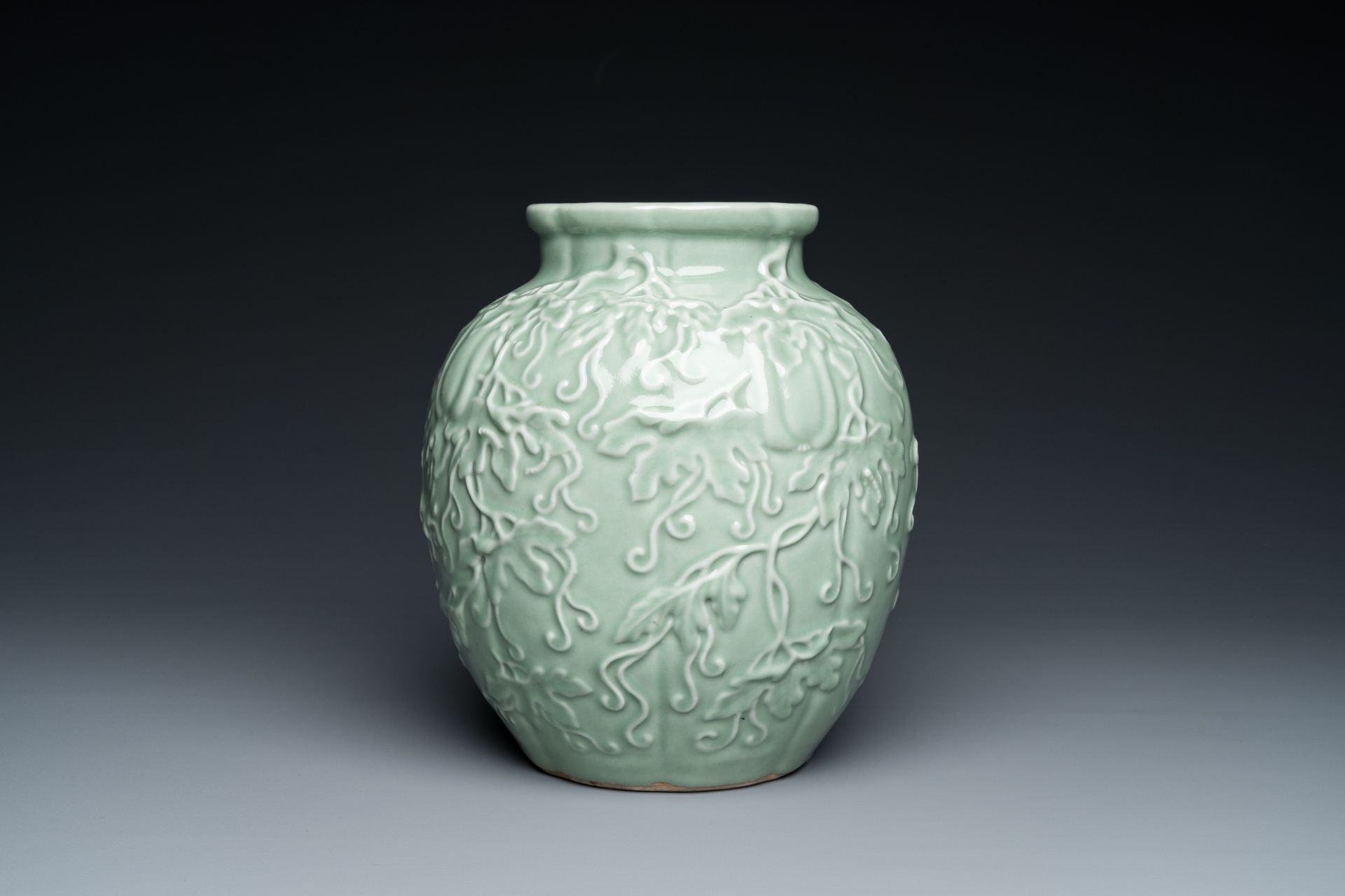 A Chinese relief-molded monochrome celadon-glazed vase, 19/20th C. - Image 3 of 6