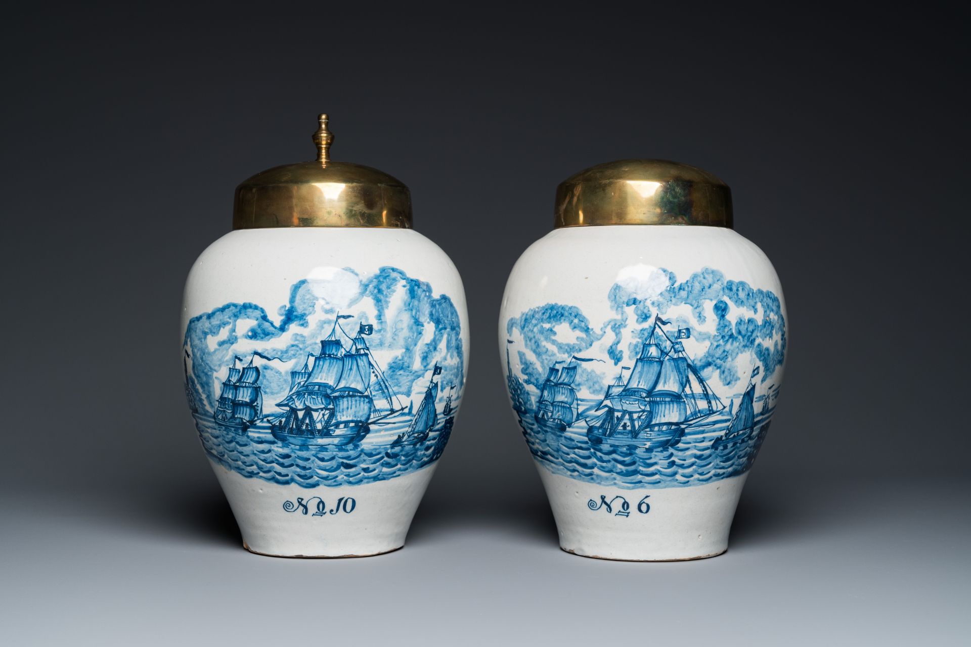 A pair of rare Dutch Delft blue and white 'maritime subject' tobacco jars with brass covers, 18th C.