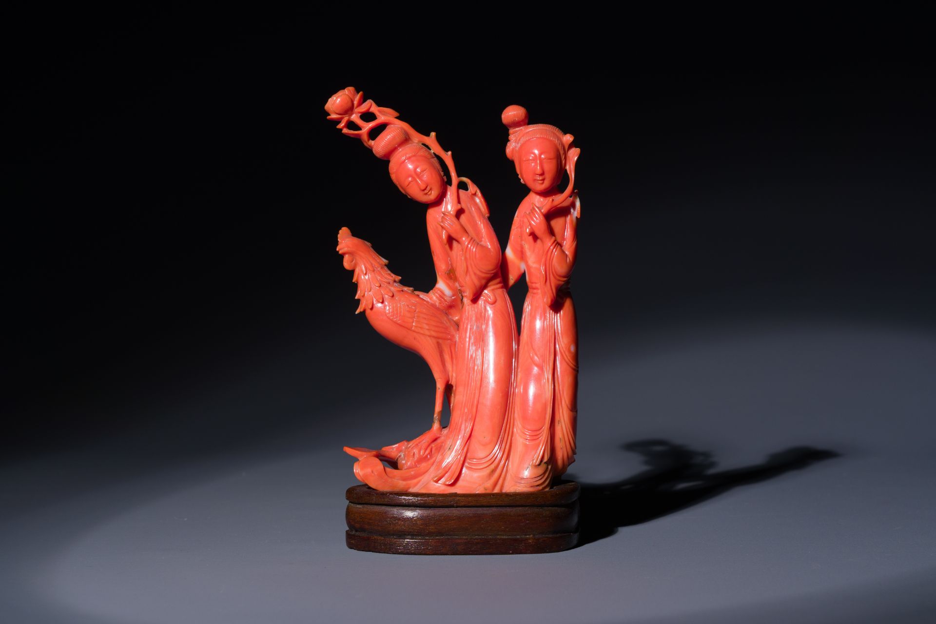 A Chinese red coral group of two ladies and a phoenix, 19/20th C.