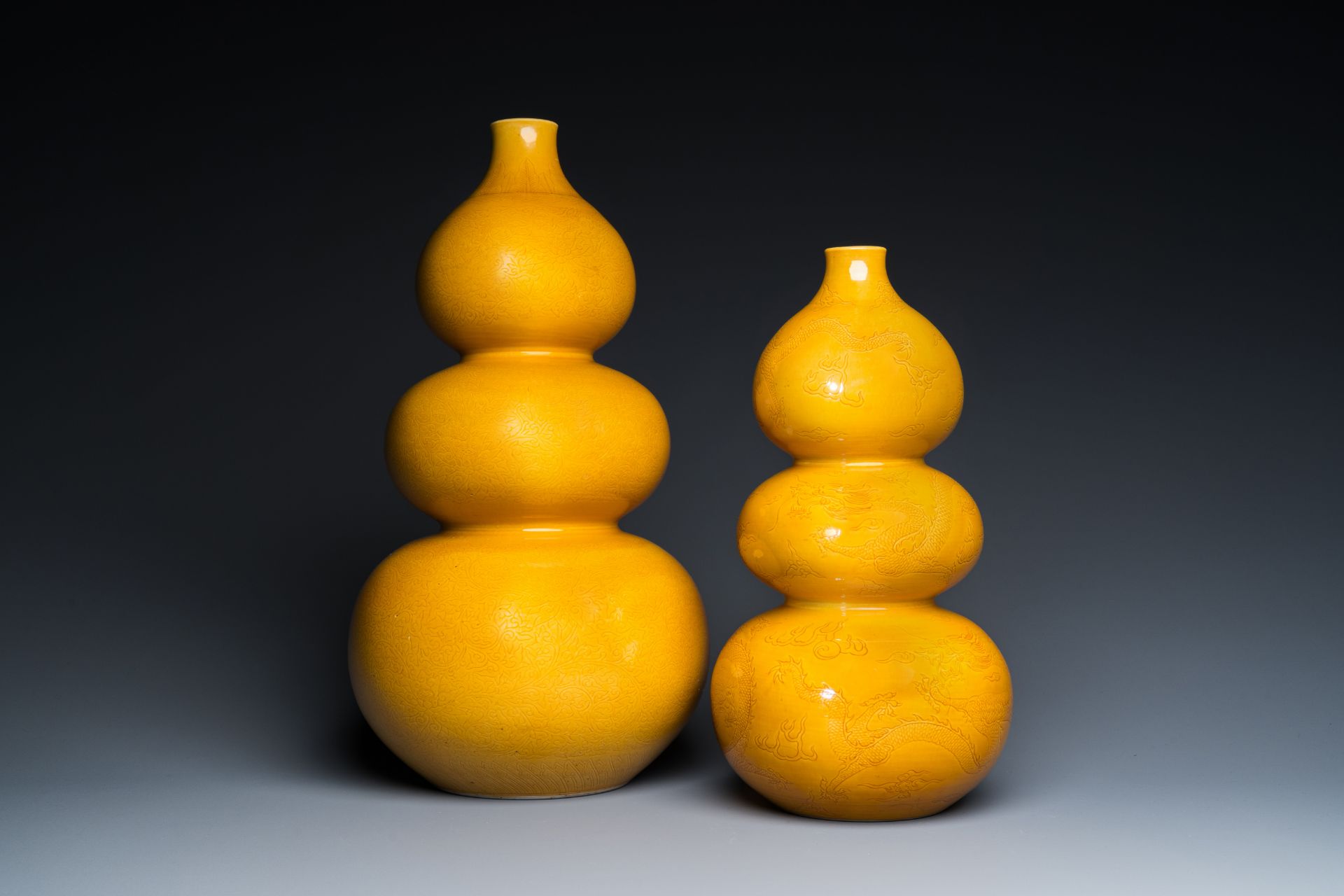 Two Chinese monochrome yellow-glazed triple gourd vases with incised designs of lotus scrolls and dr