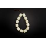A Chinese white jade 'Buddhist lion' beads bracelet, Qing