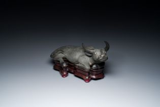 A large Chinese grisaille sculpture of a buffalo on wooden stand, 18/19th C