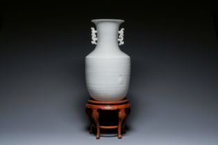 A Chinese white-glazed vase on wooden stand, 19th C.