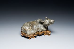 A Chinese monochrome brown-grey-glazed sculpture of a reclining water buffalo on wooden stand, 19th