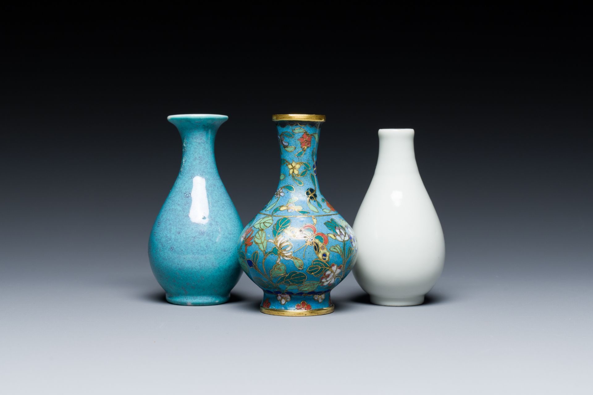 Three small Chinese bottle vases in cloisonne, white and robin's-egg-glazed porcelain, 19/20th C.