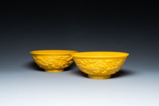A pair of Chinese yellow Beijing glass bowls with figures in mountainous landscapes, 19/20th C.