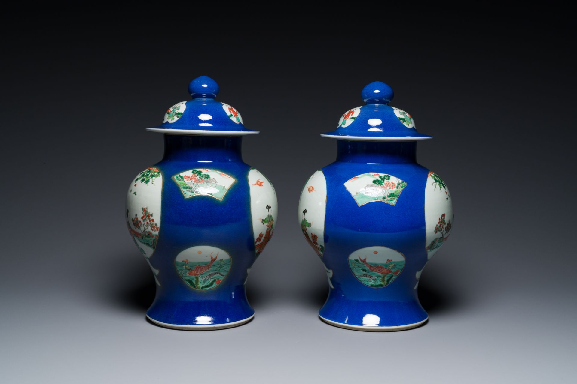 A pair of Chinese powder-blue-ground famille verte vases and covers, 19th C. - Image 2 of 6