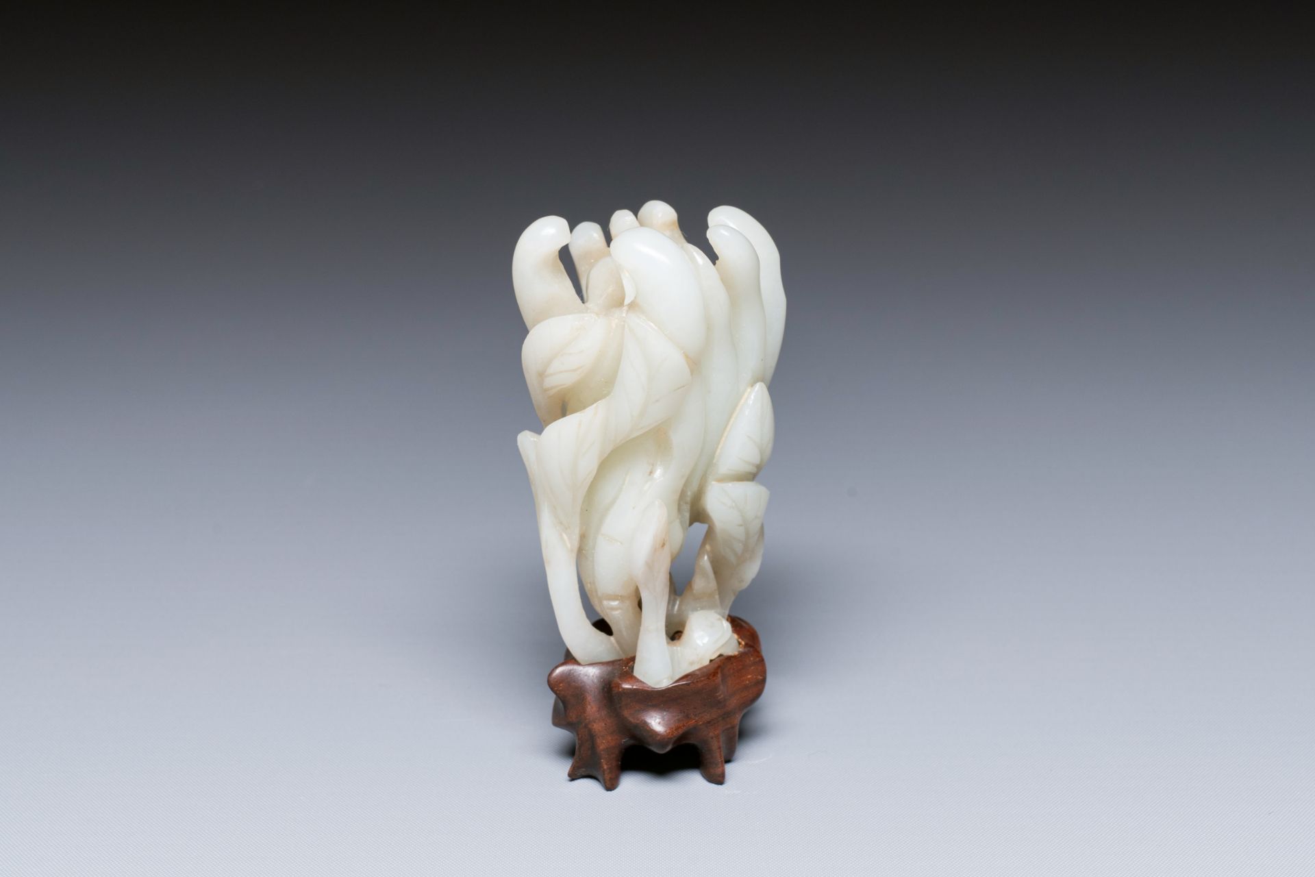 A fine Chinese white jade carving of a Buddha's hand on wooden stand, Qing