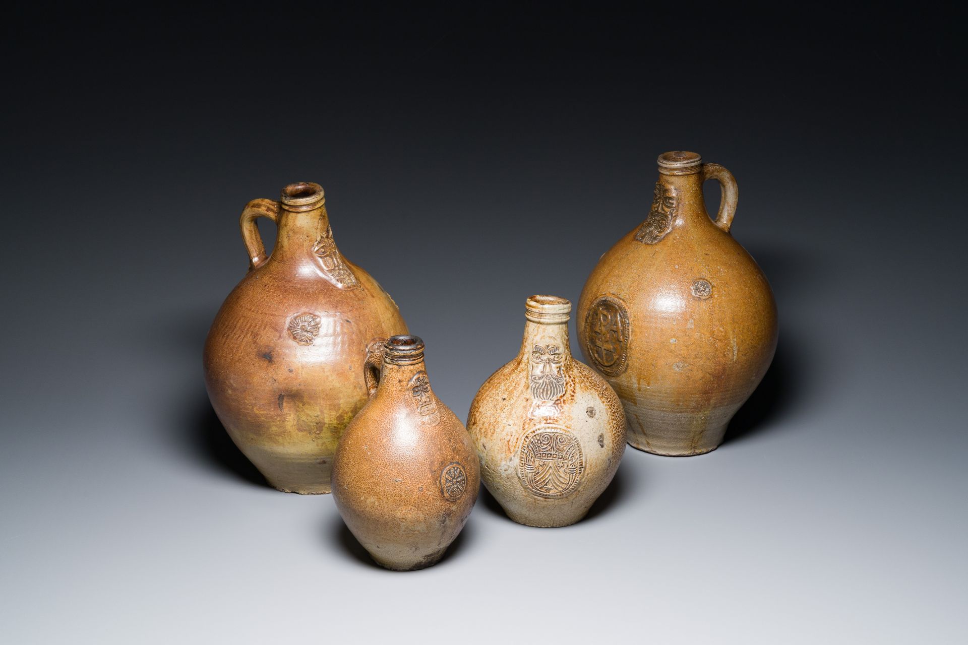 Four stoneware bellarmine jugs with various seals, Frechen and Cologne, Germany, early 17th C.