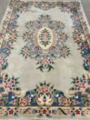 CHINESE WASHED WOOLLEN RUG - cream ground with colourful floral borders and central floral motif