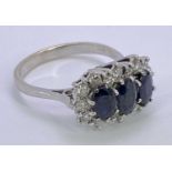 18CT WHITE GOLD DIAMOND & SAPPHIRE CLUSTER RING - having three faceted oval blue central stones, 6 x