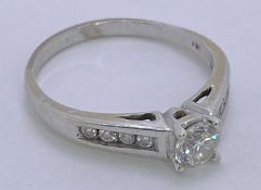 18CT WHITE GOLD DIAMOND SOLITAIRE RING - with diamond shoulders, top claw mounted near half carat