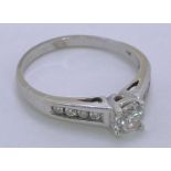 18CT WHITE GOLD DIAMOND SOLITAIRE RING - with diamond shoulders, top claw mounted near half carat