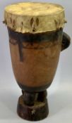 AN AFRICAN ONE PIECE WOODEN DRUM - with three supports to the circular base, 35cms H