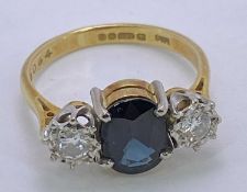 18CT GOLD & PLATINUM 3 STONE DARK BLUE SAPPHIRE & DIAMOND RING - 9 x 7mm the central stone,