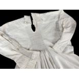 19TH CENTURY COTTON ROUND SMOCK, with floral needlework embroidered shoulders, cuffs and bodice,