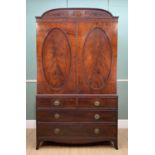 REGENCY MAHOGANY LINEN PRESS, arched reeded tablet above oval reeded panelled cupboard doors,