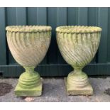 GARDEN ORNAMENTS: comprising pair composition stone shank fluted urns on socle bases, 66cm h (2)