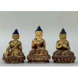 THREE SMALL GILT COPPER FIGURES OF BUDDHA, seated on double lotus thrones with hands held in
