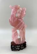 CHINESE ROSE QUARTZ CARVING OF A PHOENIX, with peony branch in its beak, wood stand Comments: