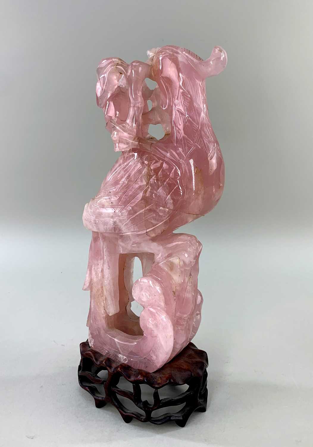 CHINESE ROSE QUARTZ CARVING OF A PHOENIX, with peony branch in its beak, wood stand Comments: - Image 2 of 3