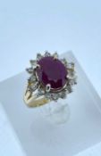 14K GOLD RUBY & DIAMOND HALO RING, the central ruby (11 x 9mms approx.) surrounded by sixteen (