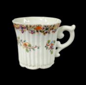 EARLY WORCESTER PORCELAIN COFFEE CUP, c. 1753, finely reeded form with a flared lobed rim, scroll