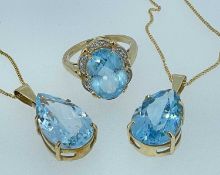 9CT GOLD SEMI PRECIOUS BLUE STONE JEWELLERY, comprising two pear-shaped pendants and an oval ring,