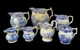 SEVEN SWANSEA BLUE & WHITE TRANSFER EARTHENWARE JUGS circa 1820, comprising three with matching ‘